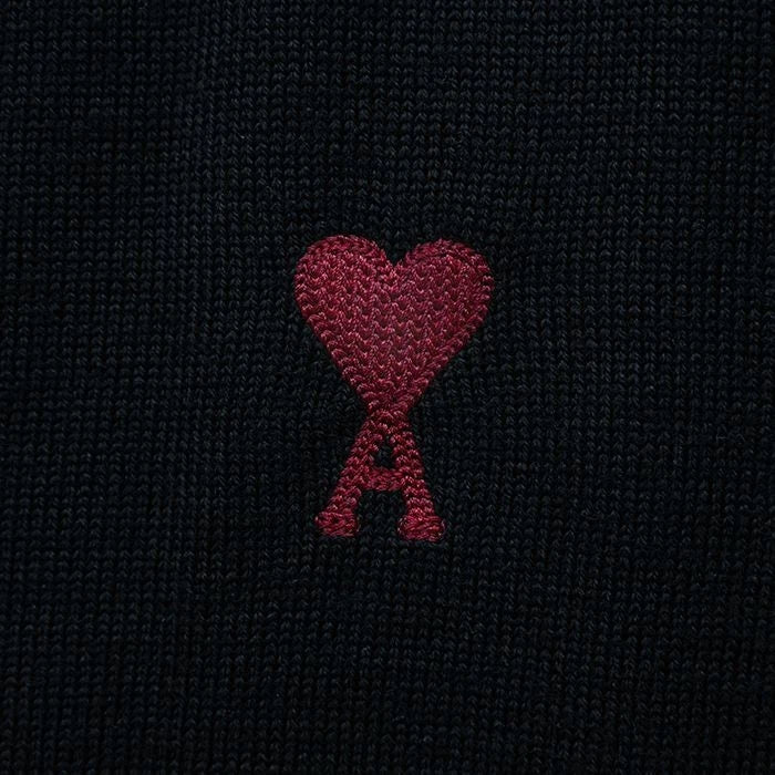 Black cardigan with a small red heart emblem on a white background