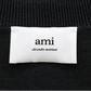 Black cardigan with a small red heart emblem on a white background