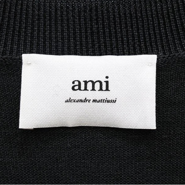 Black cardigan with a small red heart emblem on a white background