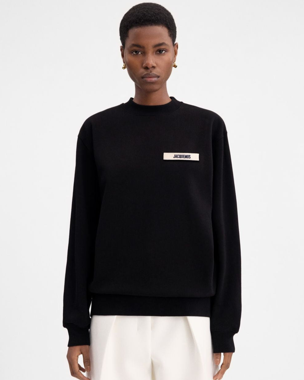 Black sweatshirt with a small white logo on a white background